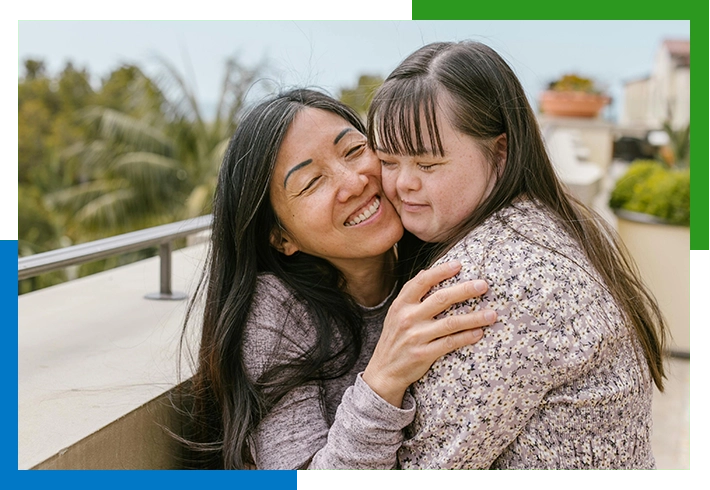 Two women embracing, smiling and happy.