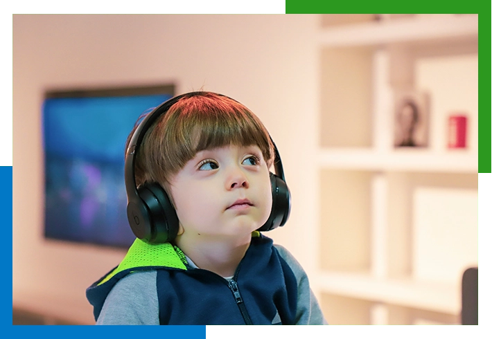 Young boy wearing headphones listening to music.