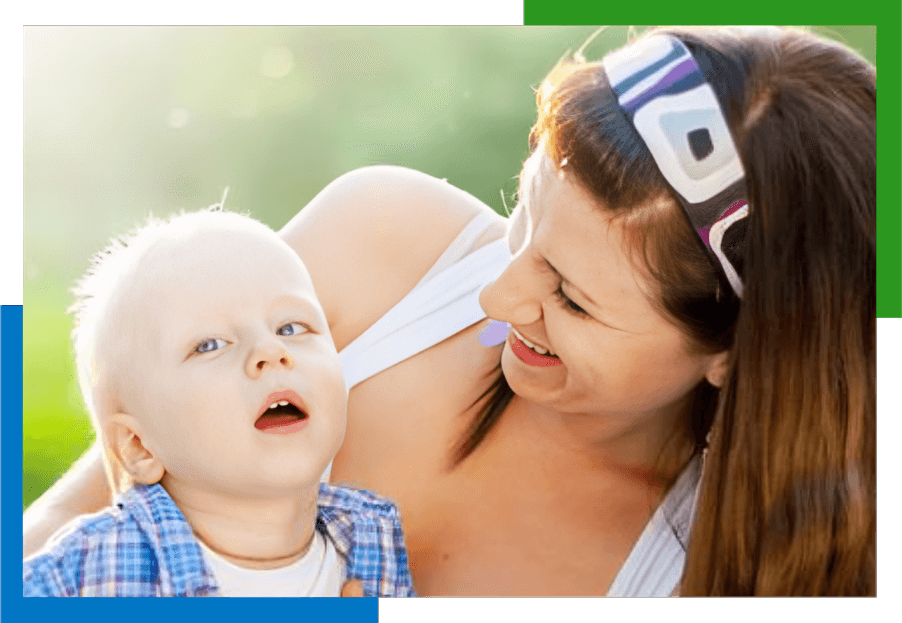 Smiling woman holding a baby boy.